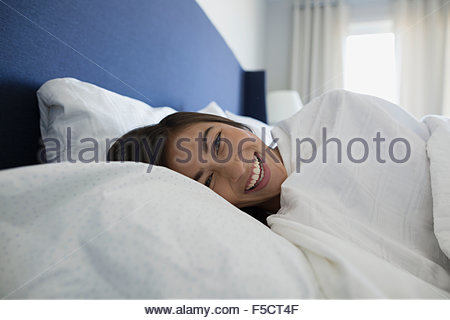 Portrait laughing woman laying in bed