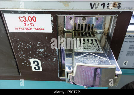 close up of coin slots in laundrette, uk Stock Photo