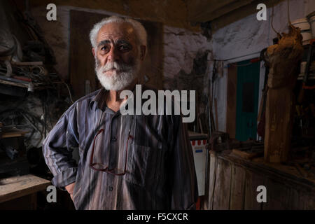 A sculptor stands in his workshop in the village of Anogia on the island of Crete in Greece Stock Photo