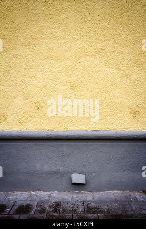 Freshly painted yellow wall and pavement Stock Photo