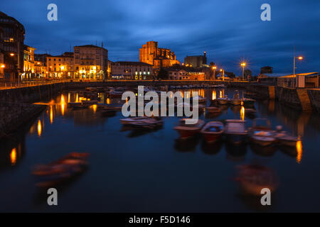 View of Castro Urdiales cityscape by dusk, with the harbor and Santa Maria de la Asuncion church. Cantabria, Spain. Stock Photo