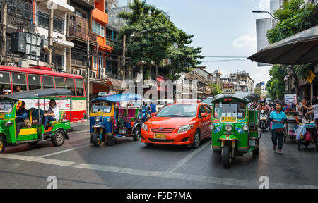Street scene, tuk-tuks and taxis waiting at traffic lights, Bangkok, Thailand Stock Photo