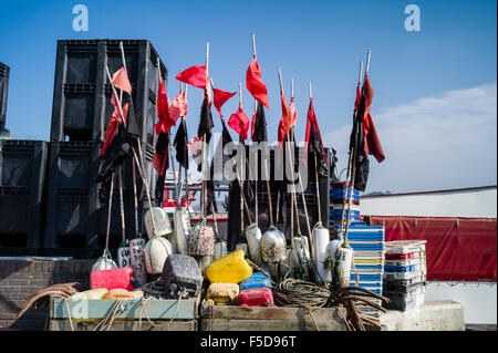 Fishing floats and their marker flags on the Normandy coastline.