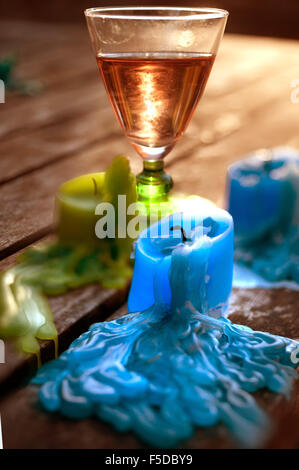 Glass of rose wine and melted candles after party Stock Photo