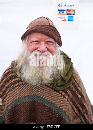 A man with a long white beard selling wood carvings at an Oregon mushroom fair in Eugene, Oregon Stock Photo