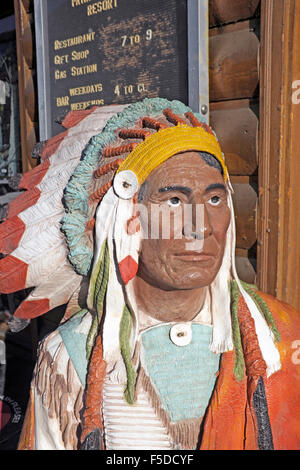 A hand-carved wooden indian at a gift shop and curio store at the eastern entrance of Yellowstone National Park Stock Photo