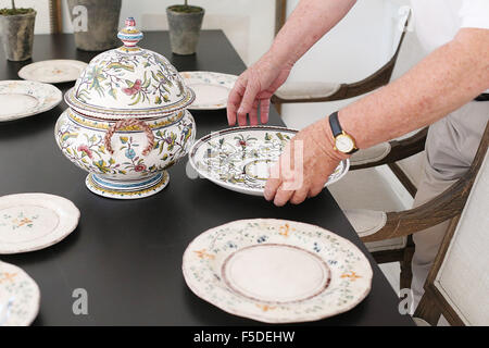 St Helena, CA, USA. 29th Oct, 2015. Thomas Bartlett arranges dishes on the dinning table in preparation to show the home for sale. © Napa Valley Register/ZUMA Wire/Alamy Live News Stock Photo