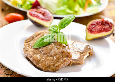 closeup of some veggie cordon bleu in a plate and a plate with salad in the background