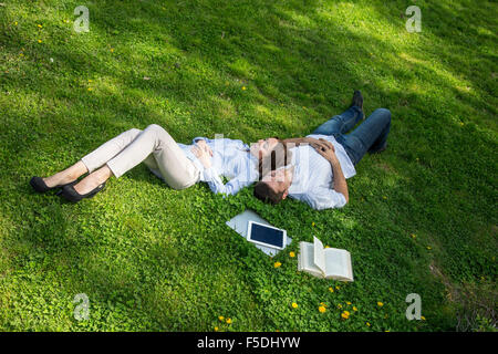 Young man and woman napping on grassy lawn Stock Photo