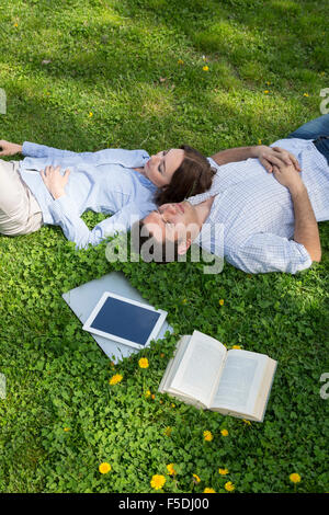 Young man and woman napping on grassy lawn Stock Photo