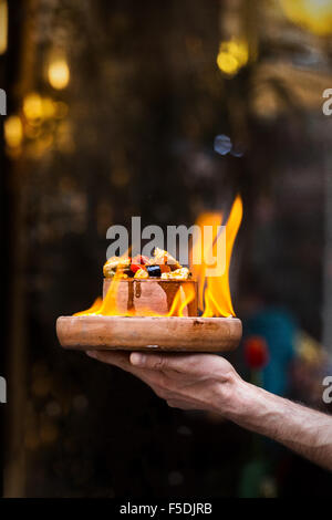 Man hand holding food plate on fire Stock Photo