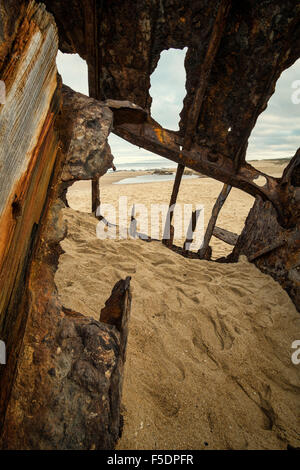 Inside a  shipwreck rotting on a sandy beach Stock Photo