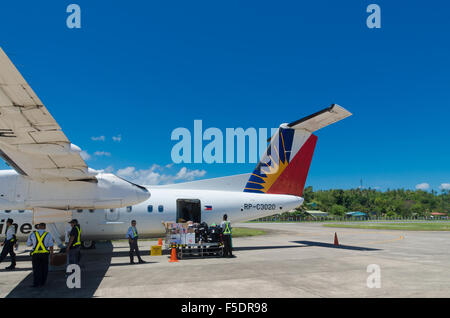 MANILA, PHILIPPINES - MAY 13, 2015: Propeller jet of Philippine Airlines (PAL) being unloaded. Since July 10, 2013 the airline n Stock Photo