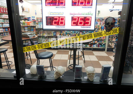 Window of gas station convenience store with Halloween police Crime Scene tape across window. Rush City Minnesota MN USA Stock Photo