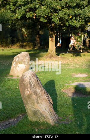 Wishing tree glimpsed behind two small standing stones of the Nine Ladies Stone Circle, Stanton Moor, Derbyshire, UK Stock Photo