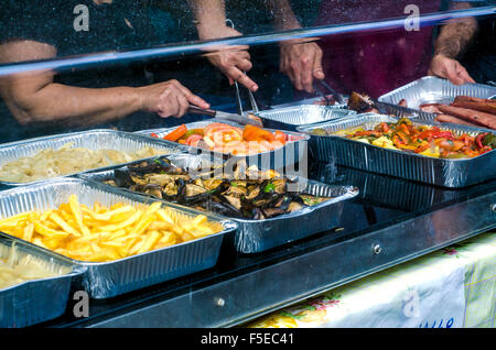 Typical Sardinian food. Counter sale with fried potatoes, tomatoes, eggplant, peppers, meat and sausage roast in a typical sardi Stock Photo