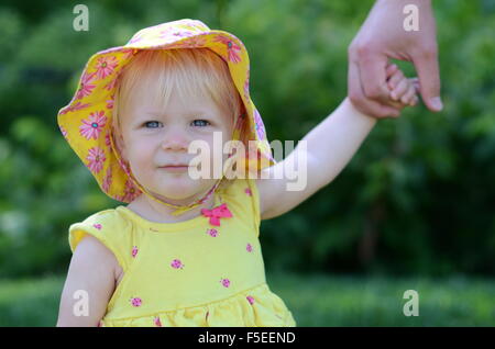 Baby girl holding her father's hand Stock Photo