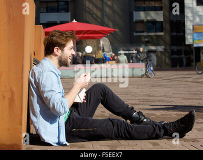 Portrait of a happy man eating food on lunch break outdoors Stock Photo