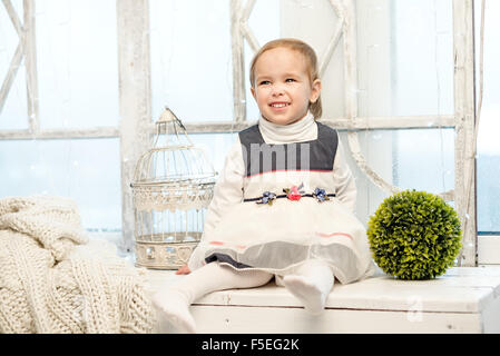 Happy smiling girl sitting on the window Stock Photo