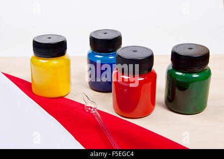 Equipment for cold batik painting isolated on white background. Close up view of different color batik paints and glass tube for Stock Photo