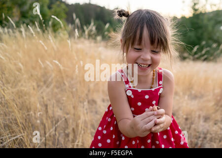 Laughing girl sitting in a field Stock Photo