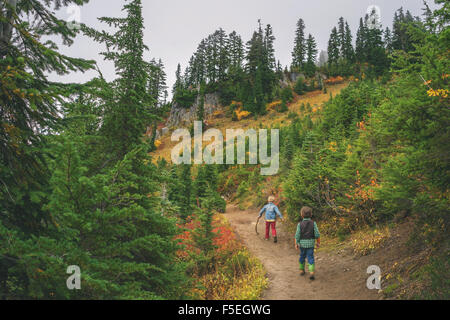 Two boys walking along mountain path Stock Photo