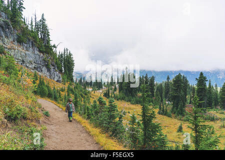 Rear view of a Boy hiking along mountain path Stock Photo