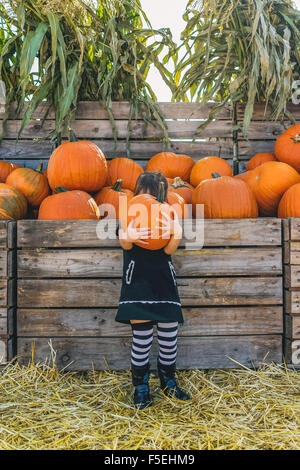 Girl holding large pumpkin at pumpkin farm Stock Photo