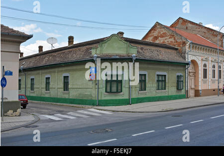 Old beautiful, low town house on the corner of two streets with a satellite dish on the roof. Stock Photo