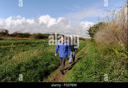 Elderly senior mature couple going for a walk along the River Rife in Ferring near Worthing Sussex UK Stock Photo