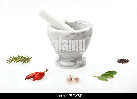 A traditional marble mortar and pestle with various herbs and spice isolated on white background Stock Photo