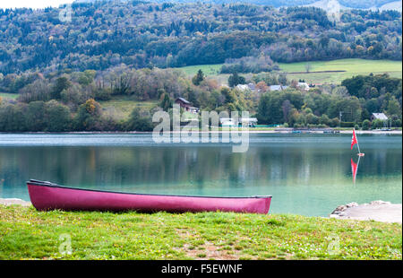 Red canoes on the Grand lac de Laffrey is one of the Laffrey lakes, located in Matheysine  in the Isere departement, France Stock Photo