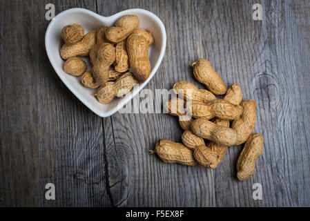 Monkey nuts in a heart shaped bowl Stock Photo