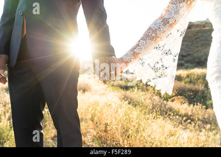 Interracial couple holding hands on their wedding day Stock Photo