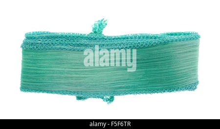 A small length of folded green ribbon cloth with a binding stitch isolated on a white background. Stock Photo