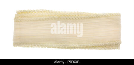 A small length of folded ivory ribbon cloth with a binding stitch isolated on a white background. Stock Photo