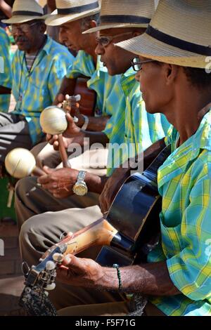 Cuban street musicians with matching straw hats and outfits playing live in the plaza in Trinidad Stock Photo