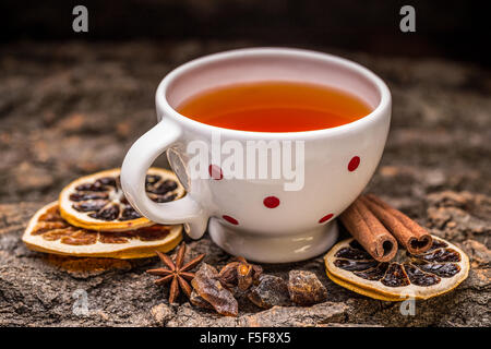 A mug of tea on the bark with orange, cinnamon and rock sugar Stock Photo