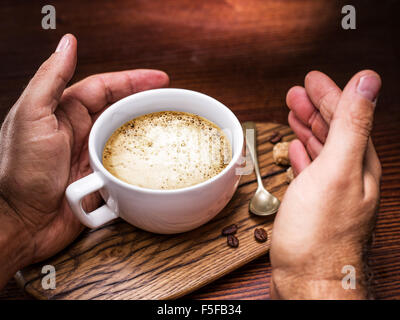 Cup of cappuccino on the aged wooden tray. Stock Photo