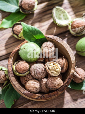 Walnuts in the wooden bowl on the table. Stock Photo