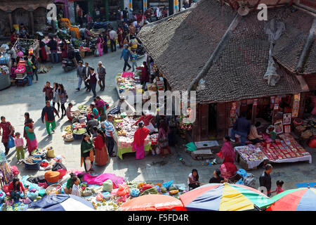 Kathmandu, Nepal - November 2, 2013: buyers and sellers at a busy street market in Kathmandu with groceries, fruits and clothes Stock Photo