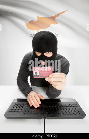 Hacker with ID card in hand and flag on background - Cyprus Stock Photo