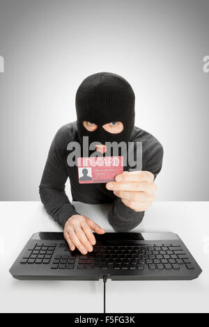 Hacker with ID card in hand Stock Photo