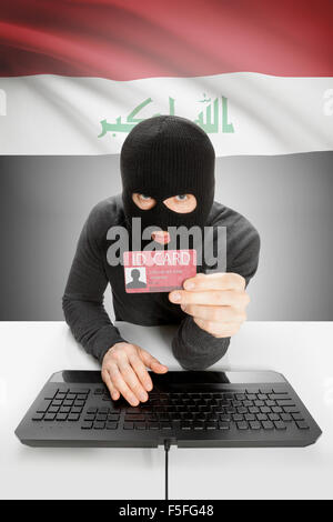 Hacker with ID card in hand and flag on background - Iraq Stock Photo