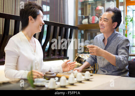 Friends drinking tea and talking in tea room Stock Photo