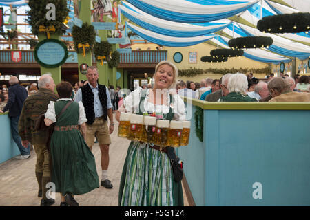 Waitress carrying masses of beer at Oktoberfest in Munich, Germany Stock Photo