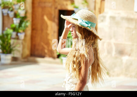 Blond teen girl tourist in Mediterranean old town profile with curly hair Stock Photo