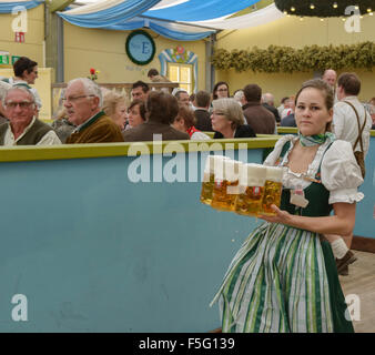 Waitress carrying masses of beer at Oktoberfest in Munich, Germany Stock Photo