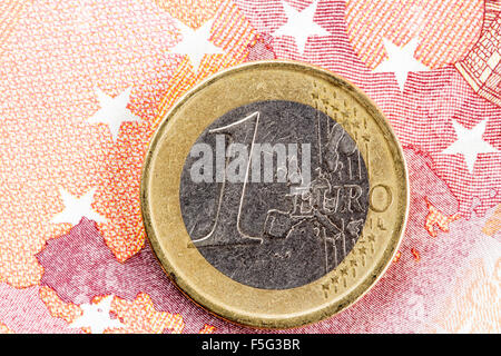 Detail of one euro coin on red ten euro banknote background Stock Photo