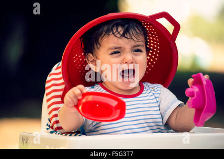 child eight month old on high chair plays outdoors in springtime Stock Photo